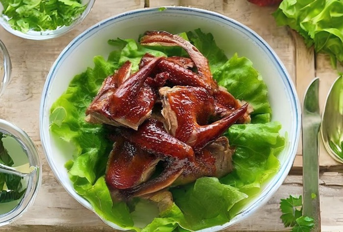 Trang trí bồ câu nướng mật ong đơn giản bằng cách lót rau xanh bên dưới