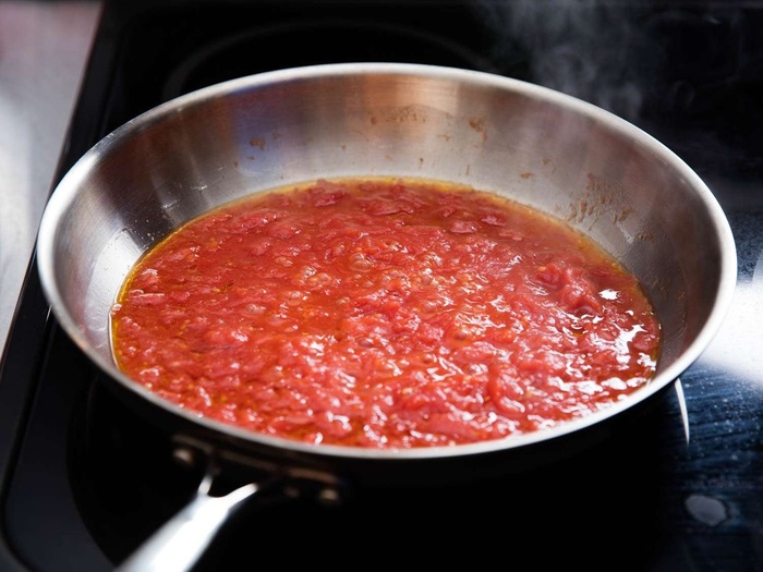 Đun sôi hỗn hợp sốt cà chua trên lửa nhỏ 