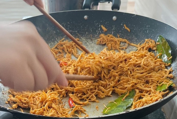 Trộn đều thịt gà xé sợi cùng sốt trên bếp với lửa nhỏ